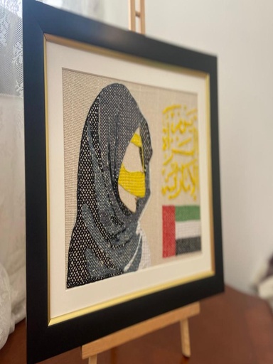 لوحة تطريز يدوي امرأة إماراتية مع البرقع الذهبي وعلم الإمارات